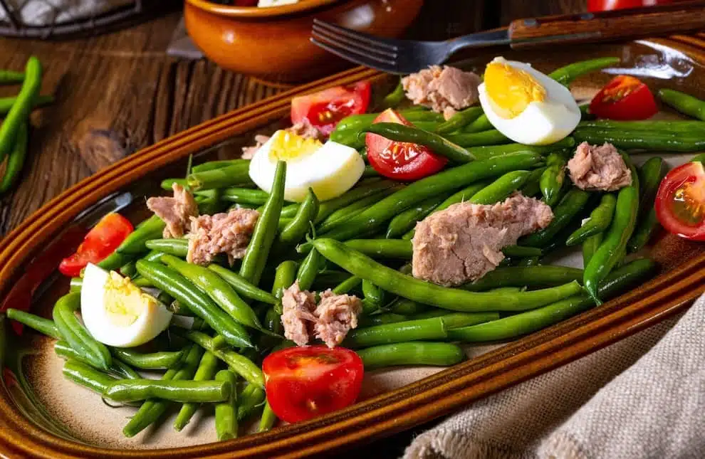 Fagiolini in insalata col uova sode e tonno su un piatto