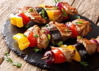 kebab di-maiale con-verdure estive in un piatto