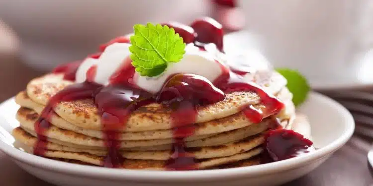 pancake con marmellata di ciliegie e yogurt serviti in un piatto