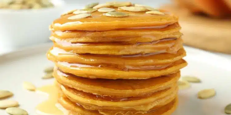 pancake alla zucca impilati con sciroppo d'acero e semi