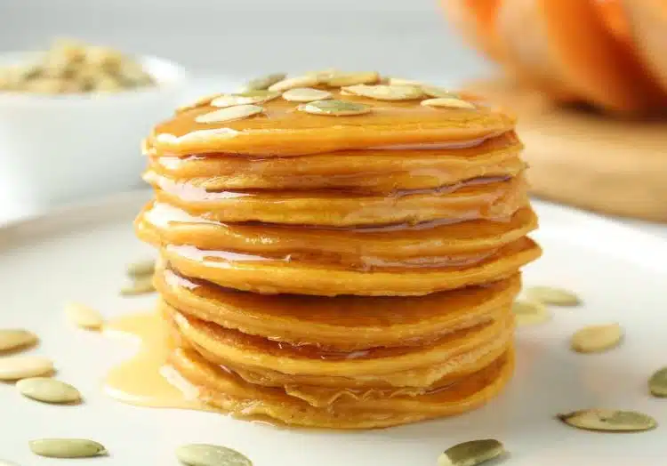 pancake alla zucca impilati con sciroppo d'acero e semi