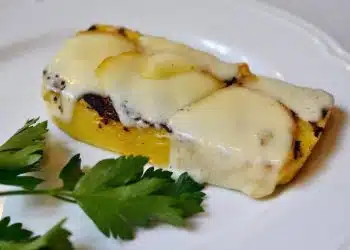 polenta a fette in padella con formaggio fuso servita in un piatto