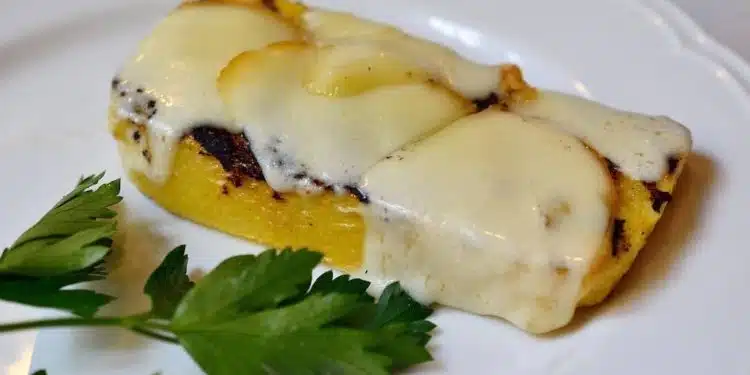 polenta a fette in padella con formaggio fuso servita in un piatto